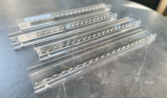Mahj Mood scalloped clear acrylic mahjong rack and pusher set of 4 laid out on a grey marble surface showing the scalloped edge detail