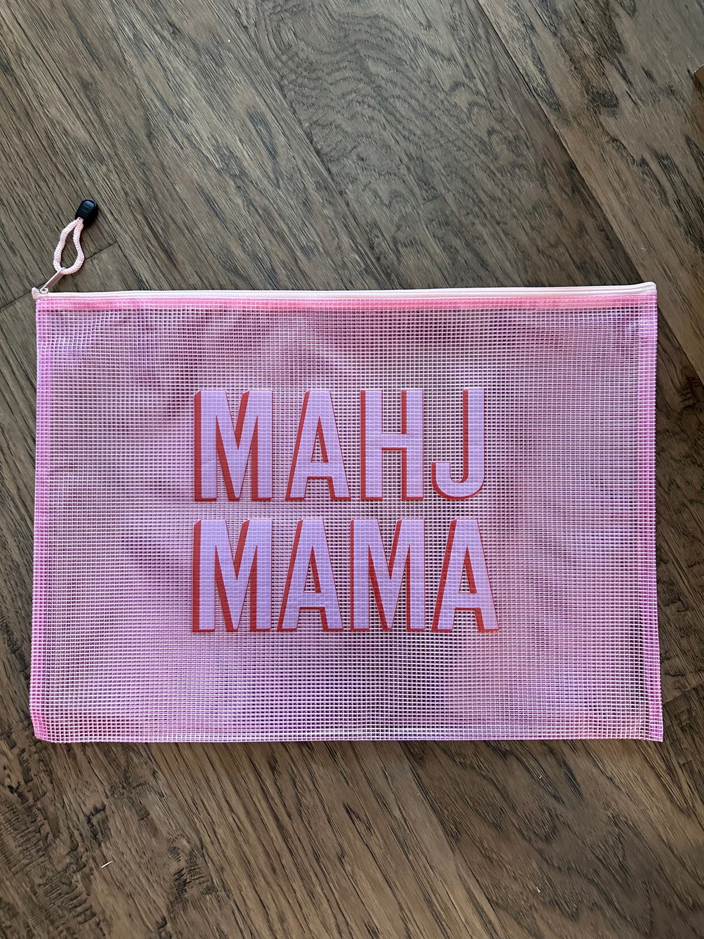 Mahj Mama pink mesh tile bag on wood floor — mahjong tile storage bag for game nights and travel