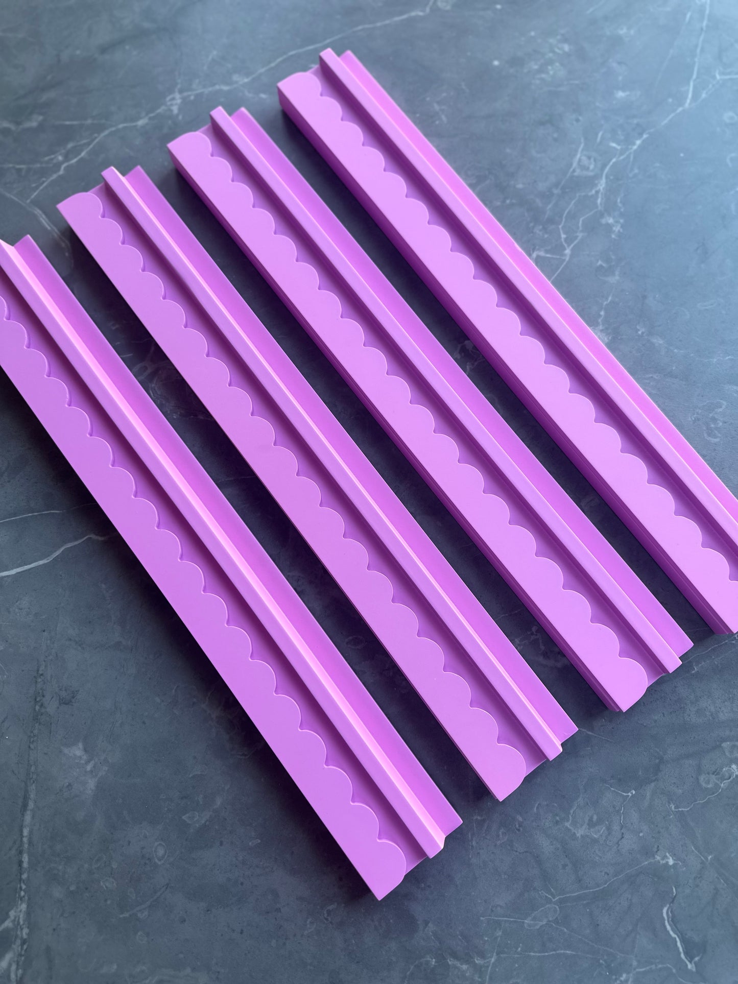 Mahj Mood scalloped pink wooden mahjong rack set of 4 laid flat overhead view on a dark marble surface showing all four racks
