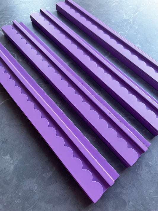 Mahj Mood scalloped purple wooden mahjong racks fanned out on grey marble surface showing the scalloped edge detail