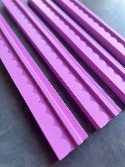 Mahj Mood scalloped pink wooden mahjong racks fanned out close-up showing the scalloped edge detail on a dark surface